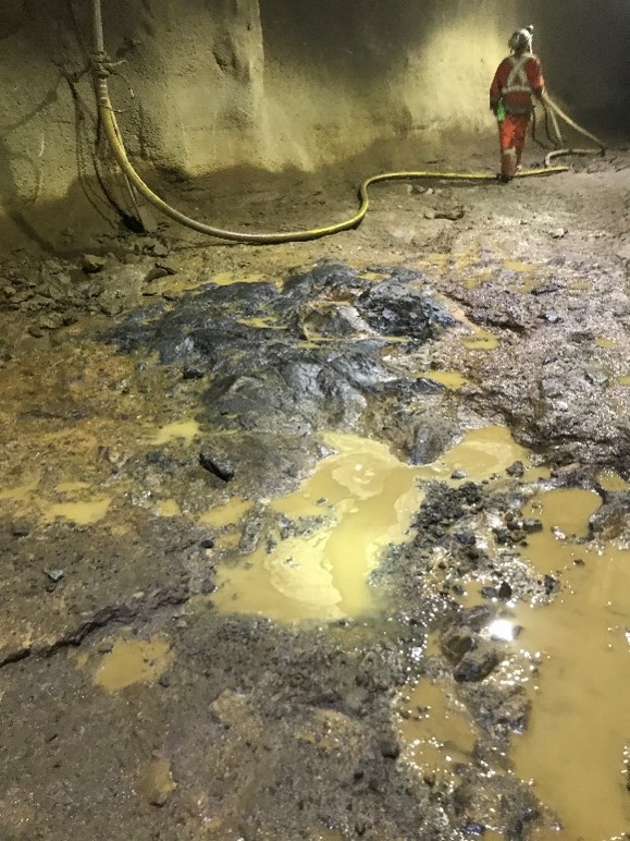 Cleaned and excavated 14” from bottom of an old drift, ballasted and tamped floor base, poured cement floor and installed a block a mortar storage area.